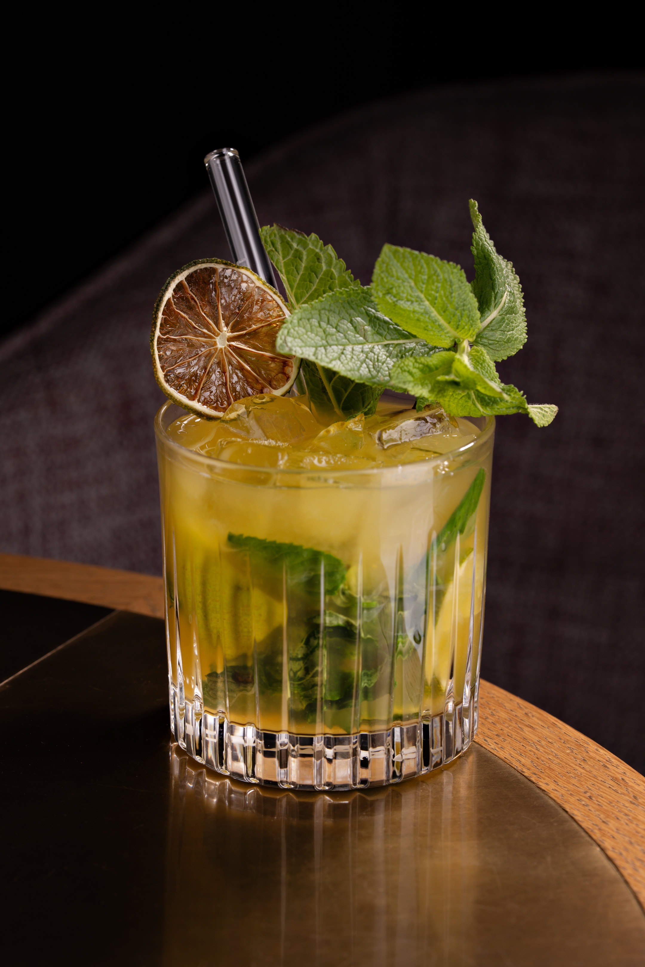 Ein Cocktail mit Minze und getrockneter Zitronenscheibe.