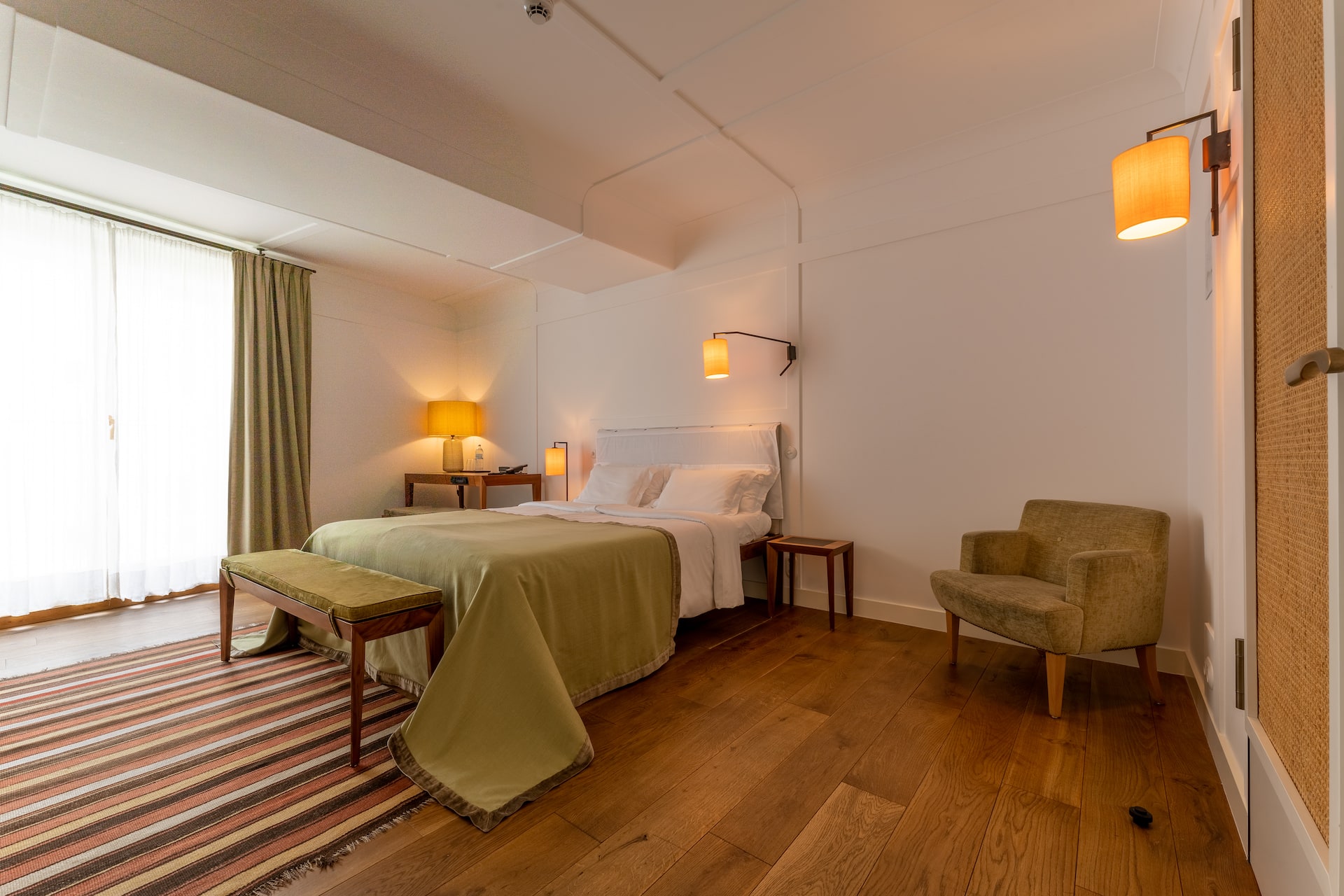 Superior room with a double bed and an armchair at the LOUIS Hotel Munich