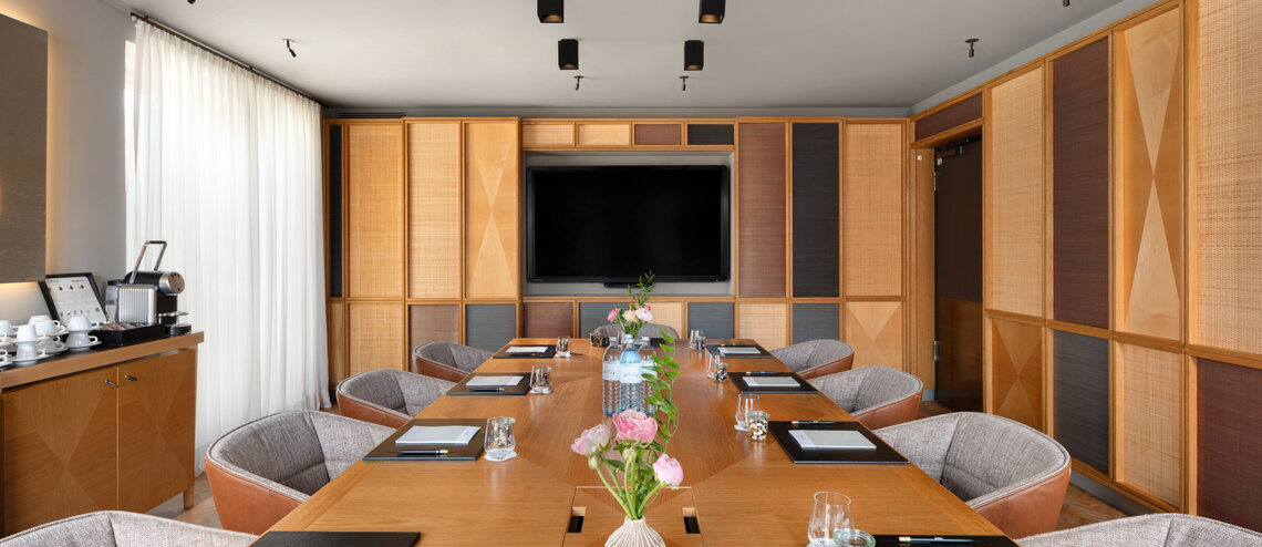 : © Tony Gigov A bright meeting room with warm wooden accents.
