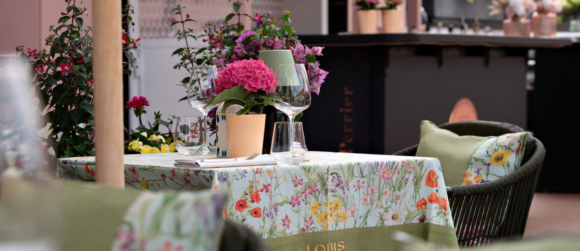 : © Tony Gigov A table on the roof terrace with wine glasses and flowers.
