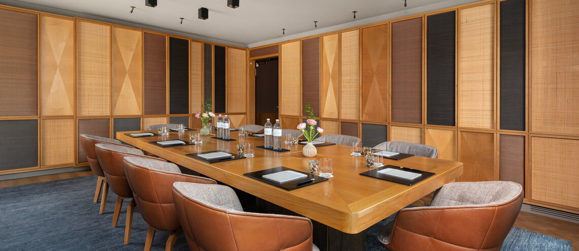: © Tony Gigov A bright meeting room with warm wooden accents.