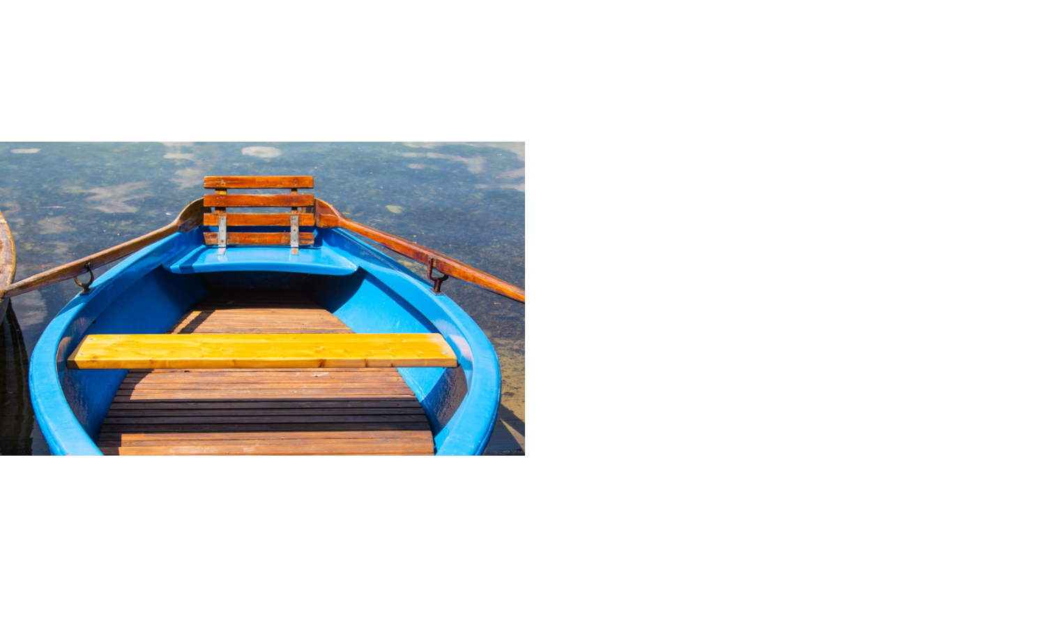 Blaues Ruderboot mit Holzbänken auf ruhigem Wasser, nahe dem LOUIS Hotel München.