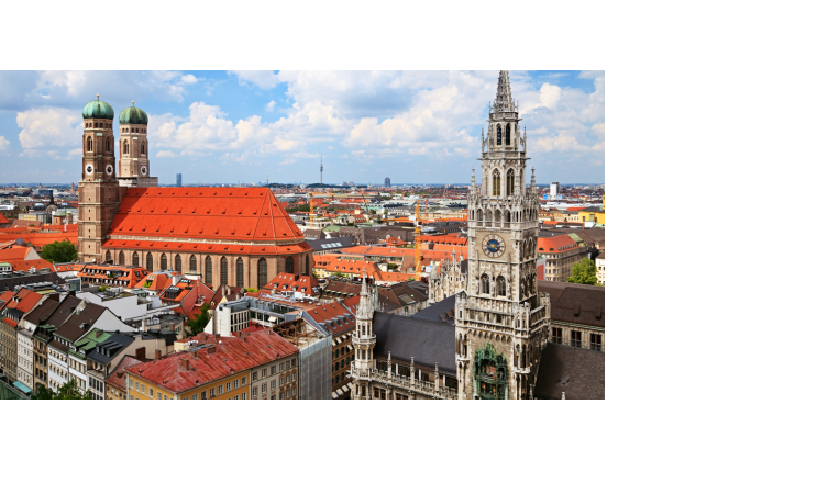 Stadtansicht von München mit Frauenkirche und neugotischem Rathaus bei blauem Himmel.