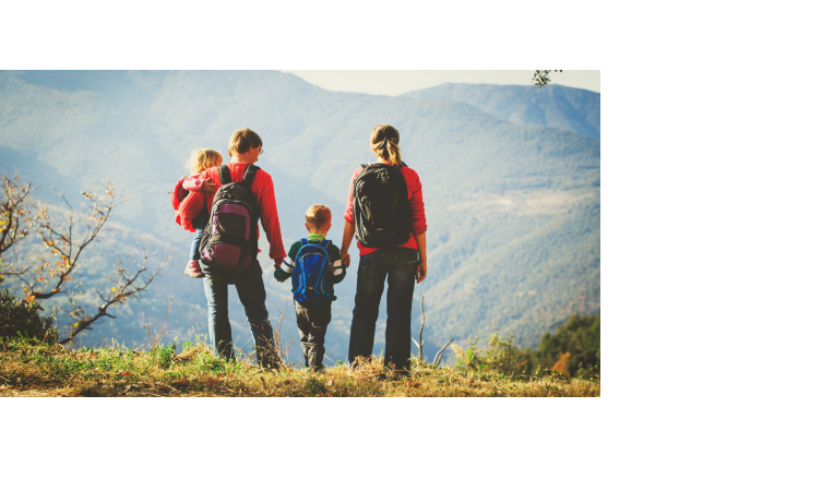 Familie mit Rucksäcken blickt auf malerische Berglandschaft.
