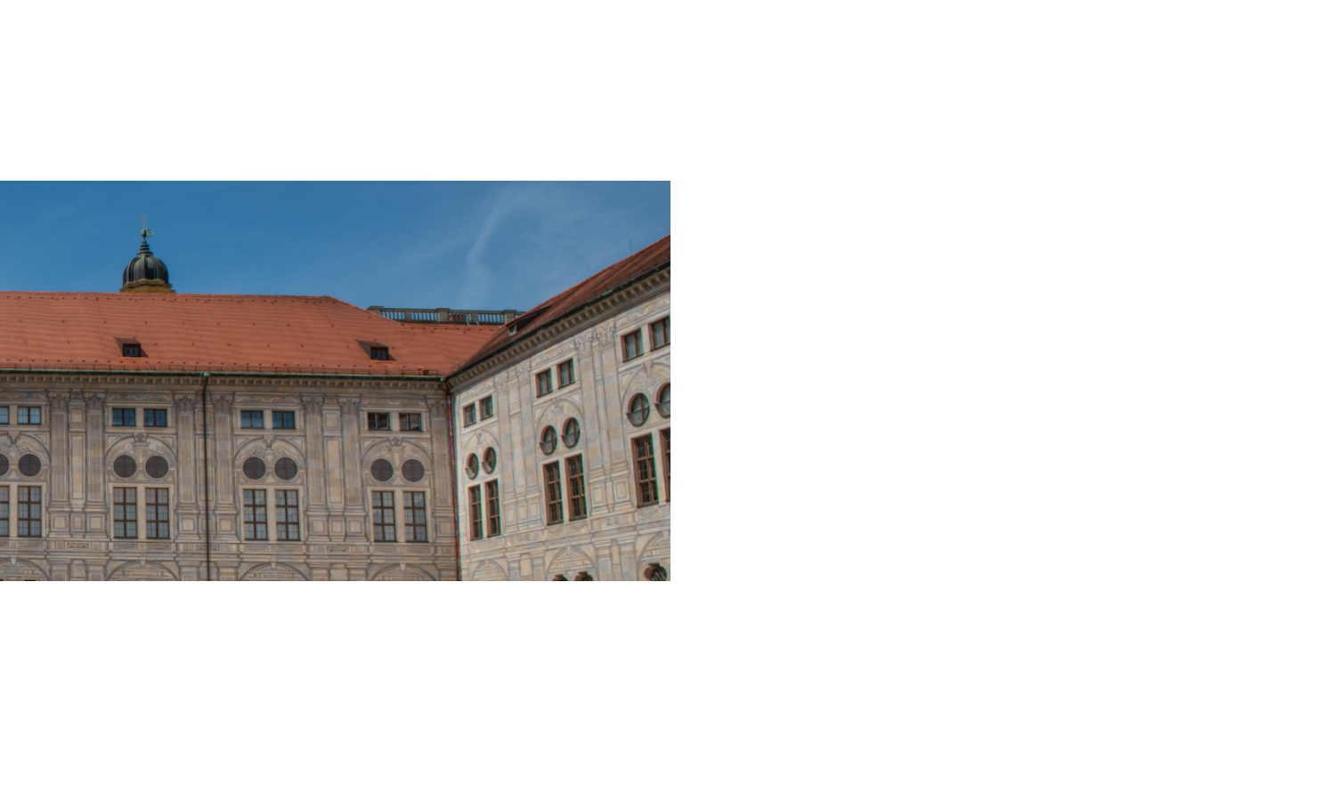 Historische Fassade mit verzierten Fenstern und rotem Dach unter blauem Himmel.