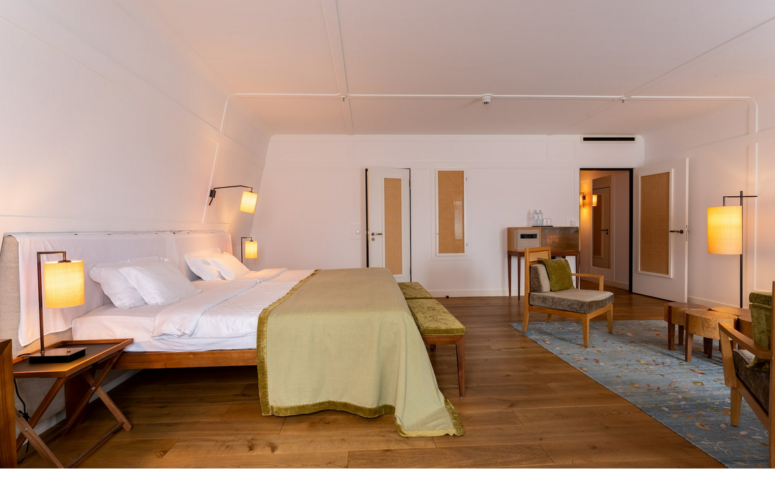 Suite with a double bed and living area at the LOUIS Hotel Munich