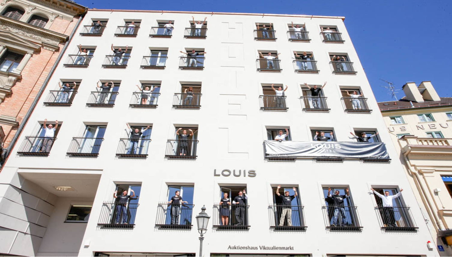 Employees waving from windows at louis hotel munich hotelrooms