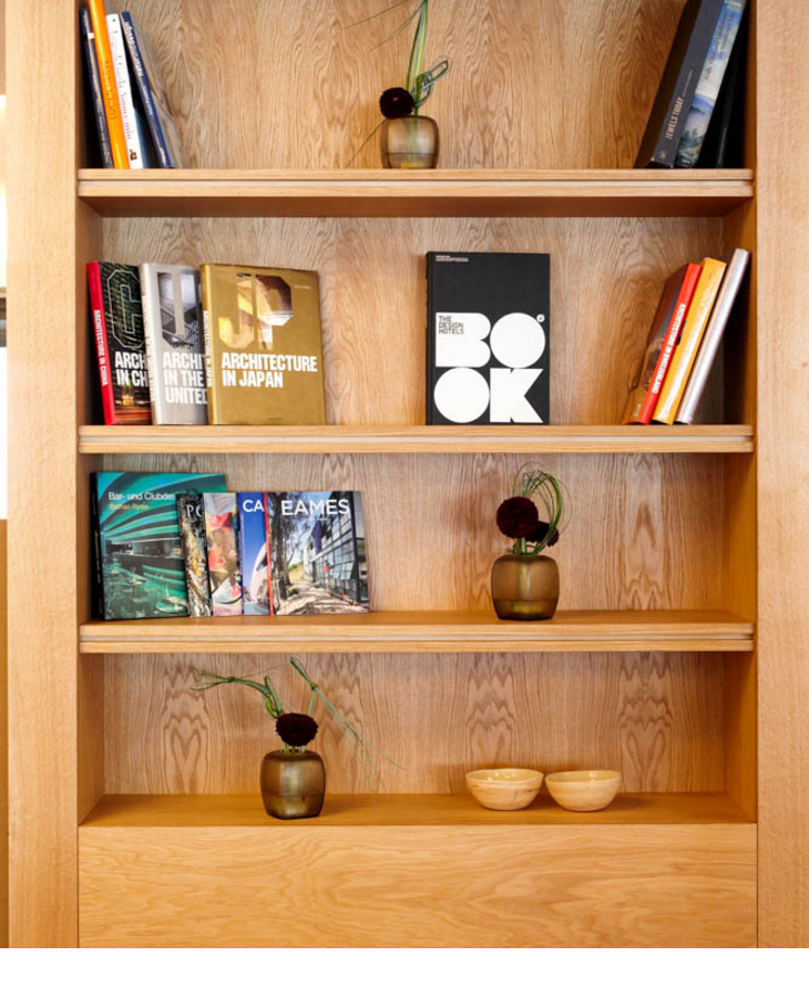 Wooden shelf in the LOUIS Hotel with architecture books, vases and decorative bowls.