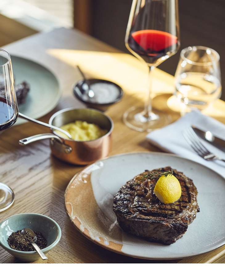 Steak und Rotwein auf einem Tisch im Grillroom Restaurant im LOUIS Hotel in München