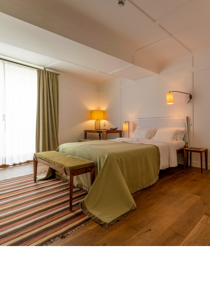 Superior room with a double bed and an armchair at the LOUIS Hotel Munich