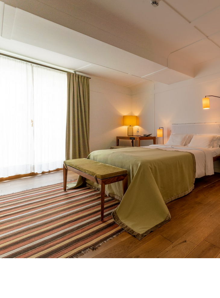 Superior room with a double bed and an armchair at the LOUIS Hotel Munich