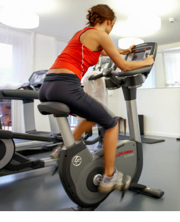 Woman on bike in the fitness gym of the LOUIS Hotel Munich