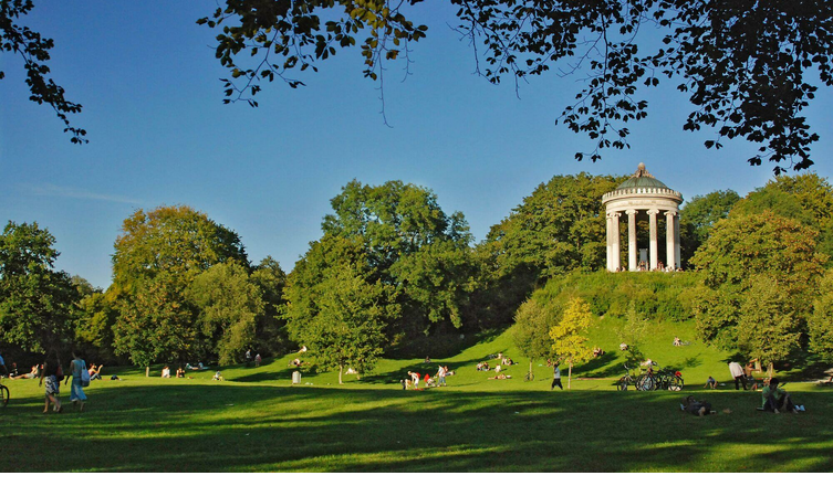 Grüne Parklandschaft mit Menschen, die entspannen; im Hintergrund ein Rundtempel auf einem Hügel unter blauem Himmel.