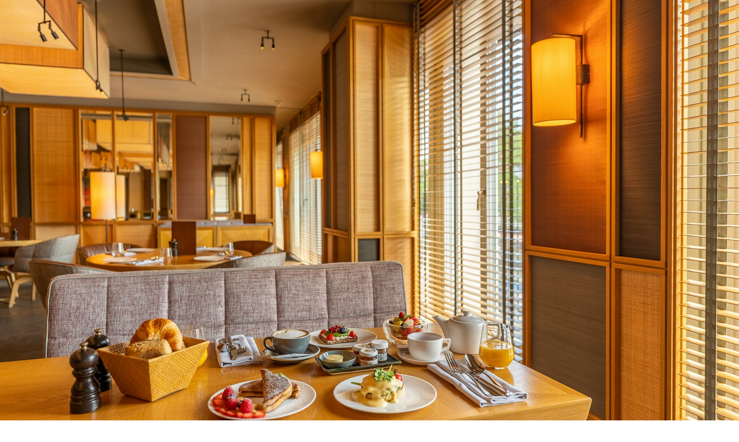 breakfast at the Viktualienmarkt in the LOUIS Hotel München Cozy hotel restaurant with a laid breakfast table, wooden furniture and warm lighting.