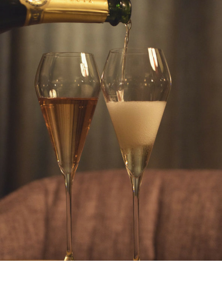 Champagne is poured into two glasses in the Sparkling Bar at the LOUIS Hotel Munich