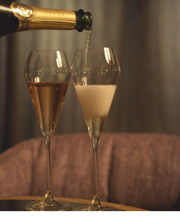 Champagner wird in zwei Gläser eingegossen in der Sparkling Bar im LOUIS Hotel Muenchen