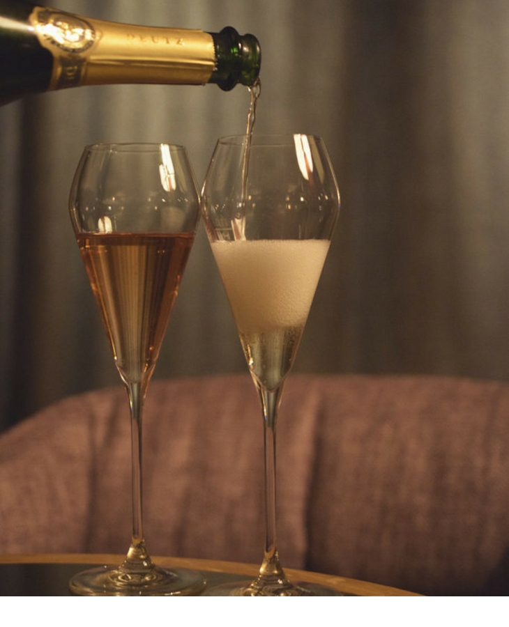 Champagne is poured into two glasses in the Sparkling Bar at the LOUIS Hotel Munich