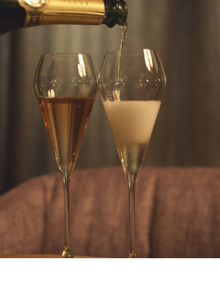 Champagner wird in zwei Gläser eingegossen in der Sparkling Bar im LOUIS Hotel Muenchen