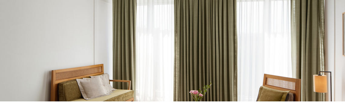 Blick vom Schreibtisch auf gemütliches Sofa und Sessel mit orientalischem Teppich.