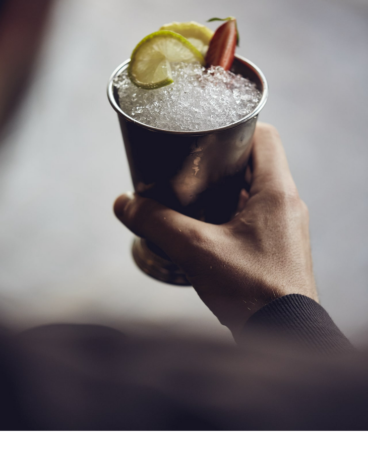 Gast mit Cocktail in der Hand im Grillroom Restaurant im LOUIS Hotel Muenchen