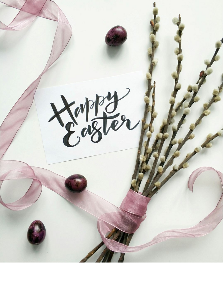 Osterkarte mit "Happy Easter", rosa Schleife, Weidenkätzchen und violetten Eiern auf weißem Hintergrund.