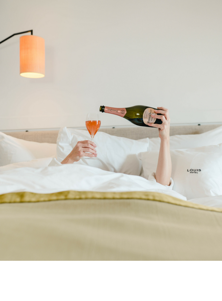 Kuscheliges Bett und eine Flasche Champagner im The LOUIS Hotel in München | Angebot Wochenende - Weekend rate
